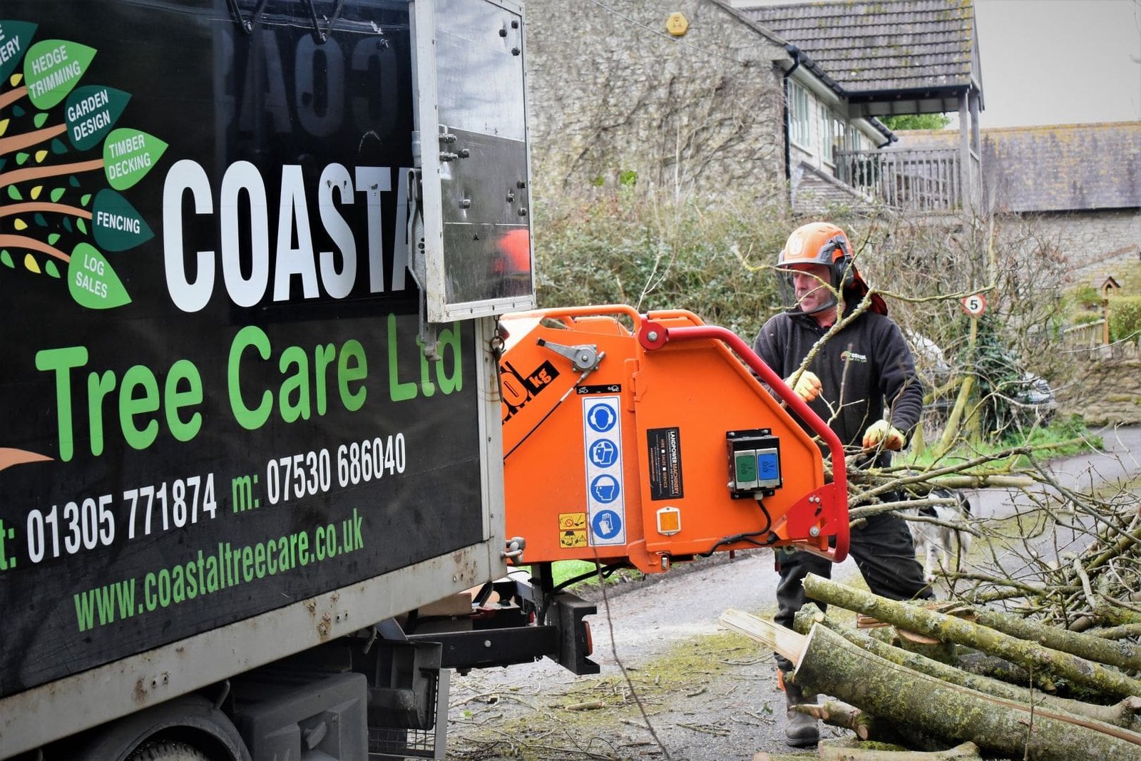 Coastal tree care worker with van loading brush waste