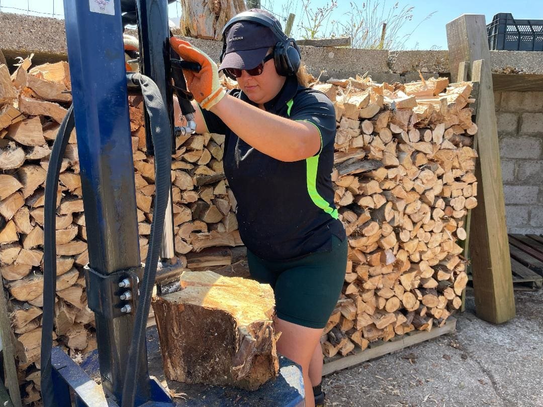 Team culbreth Olivia splitting logs and stacking them for firewood